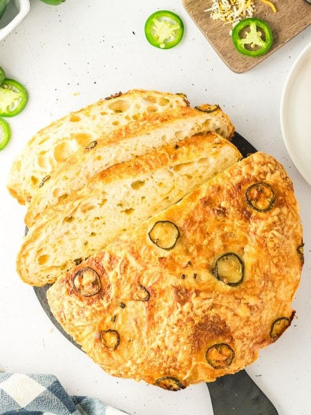 Overhead view of a sliced Jalapeño Cheddar Bread loaf on a slate board.