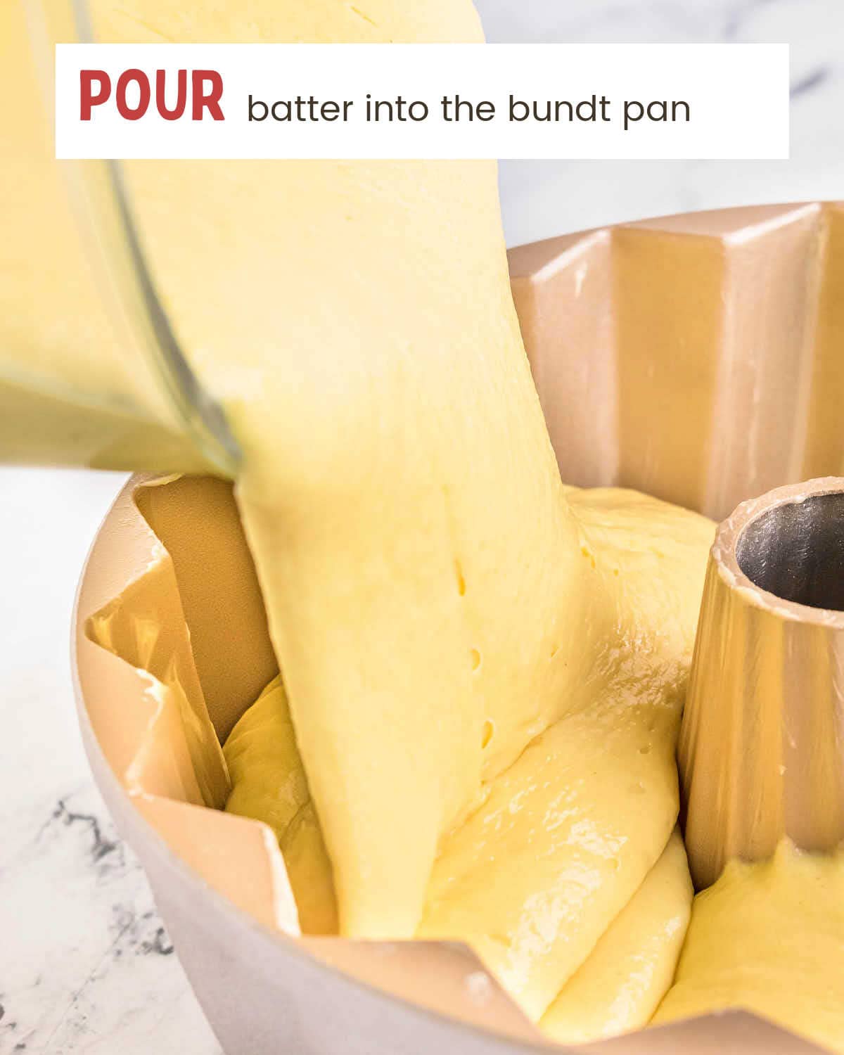Thick batter flowing from the bowl into a gold bundt pan.