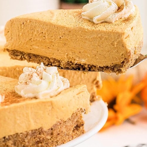 A slice of No Bake Pumpkin Cheesecake on a cake server with the whole dessert below.