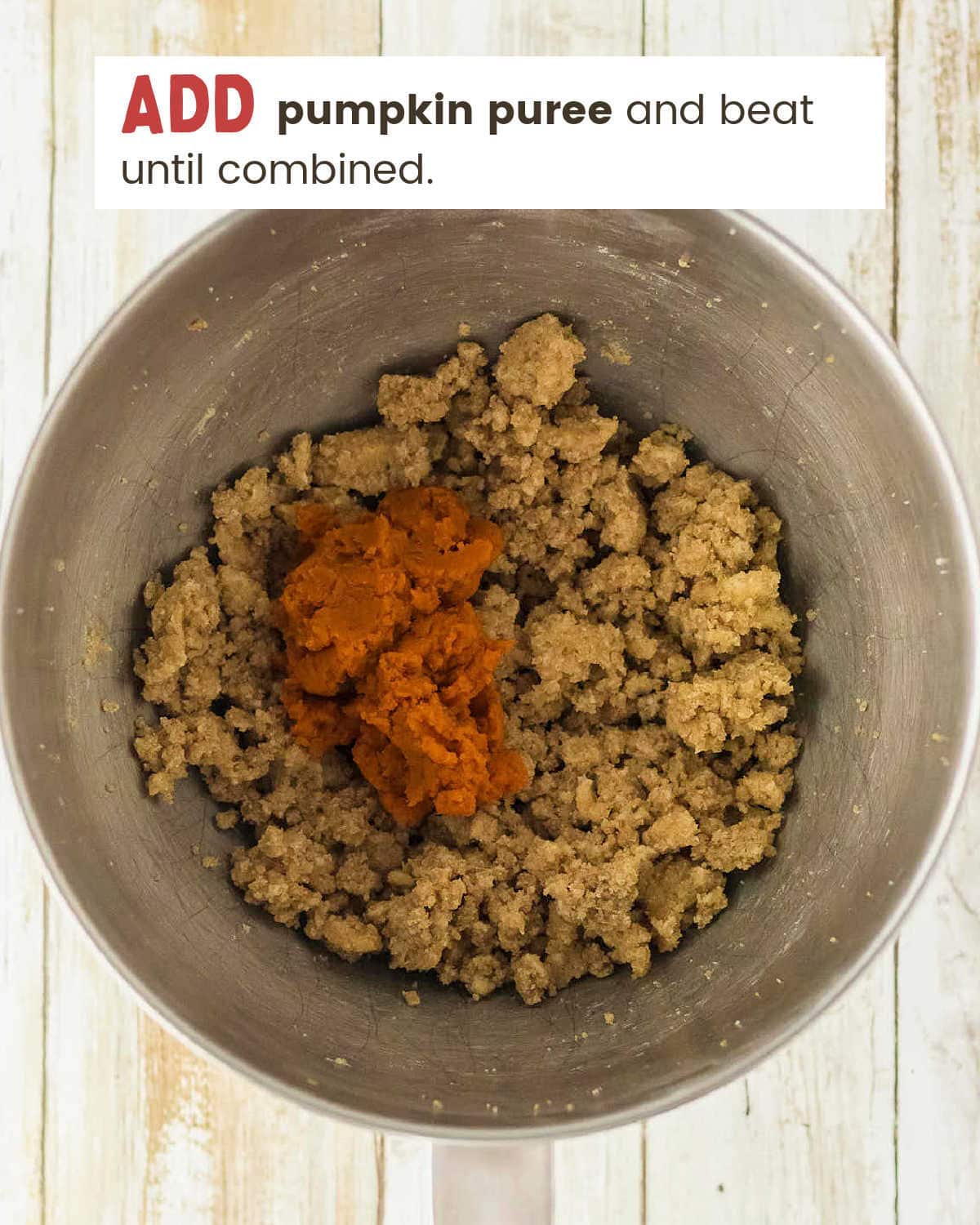 Flour mixture added to the pumpkin cookie dough in a mixer bowl.