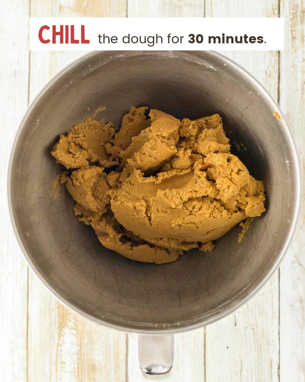 Thick pumpkin cookie dough in a stainless steel mixer bowl.