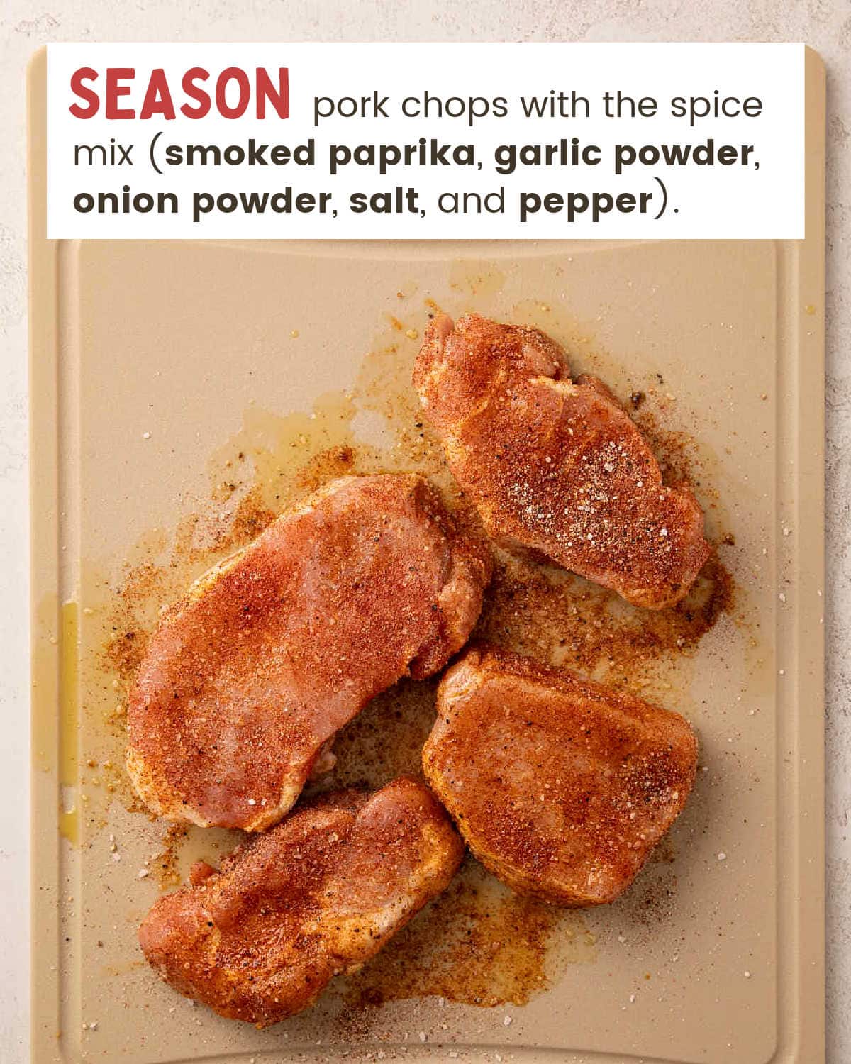 Raw pork chops coated in seasoning on a cutting board.