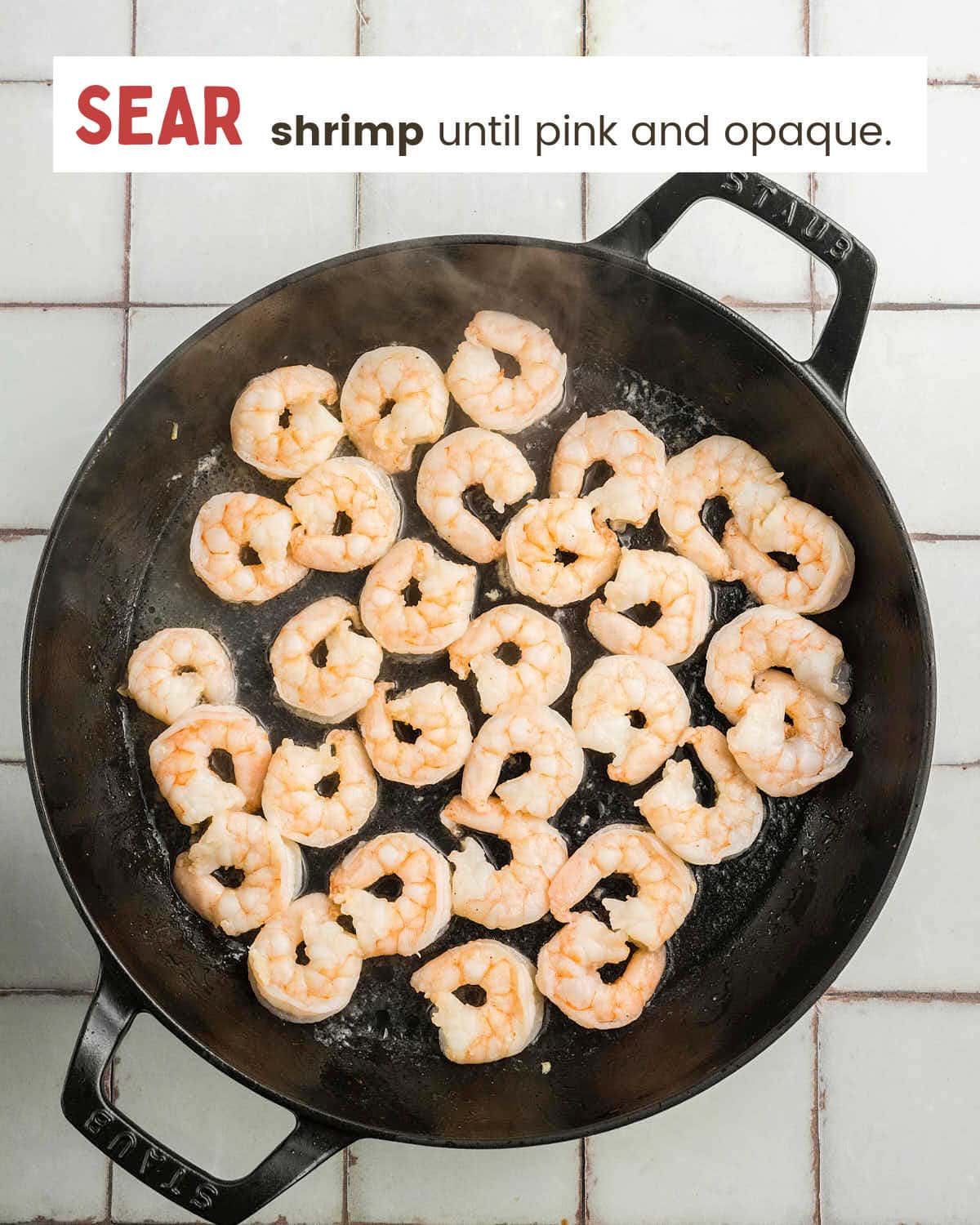 Shrimp cooking in the skillet until pink and opaque.