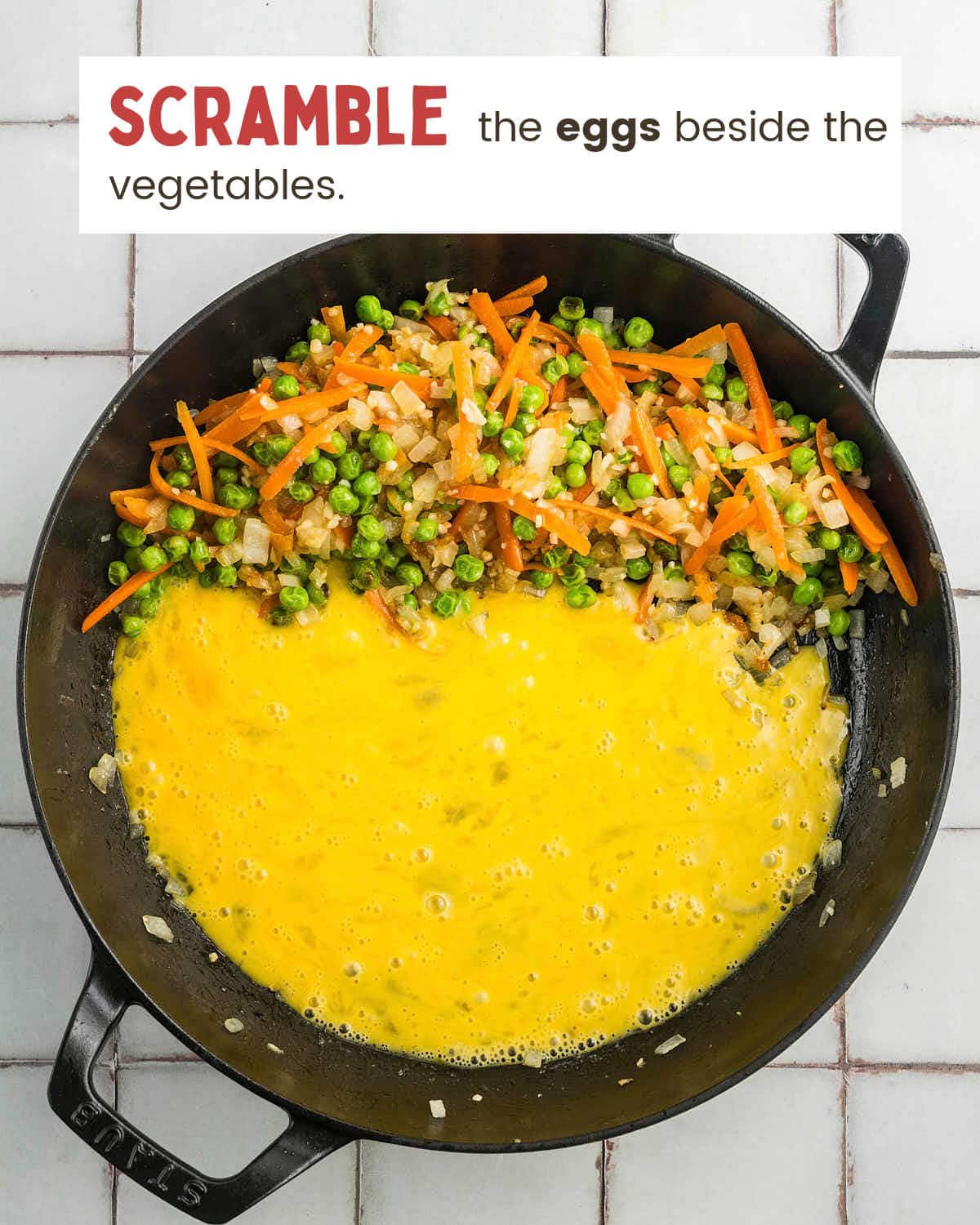 Beaten eggs poured into one side of the skillet beside the vegetables.