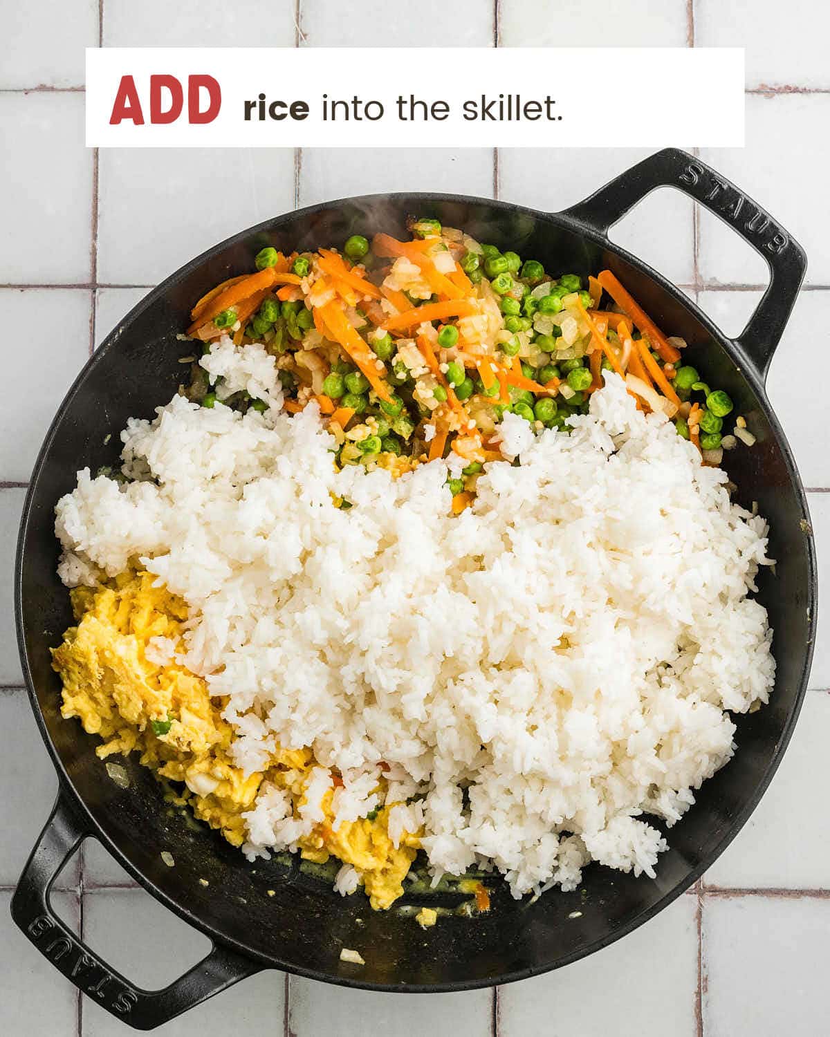 Cooked rice added to the skillet with the vegetables and eggs.