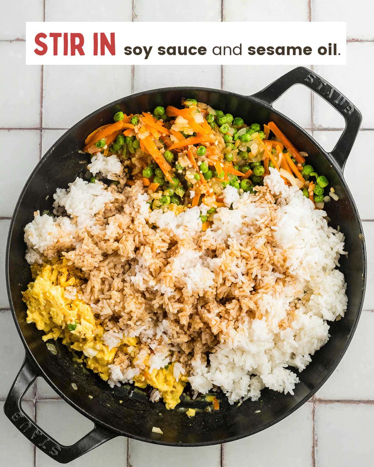 Soy sauce drizzled over the rice in the skillet.