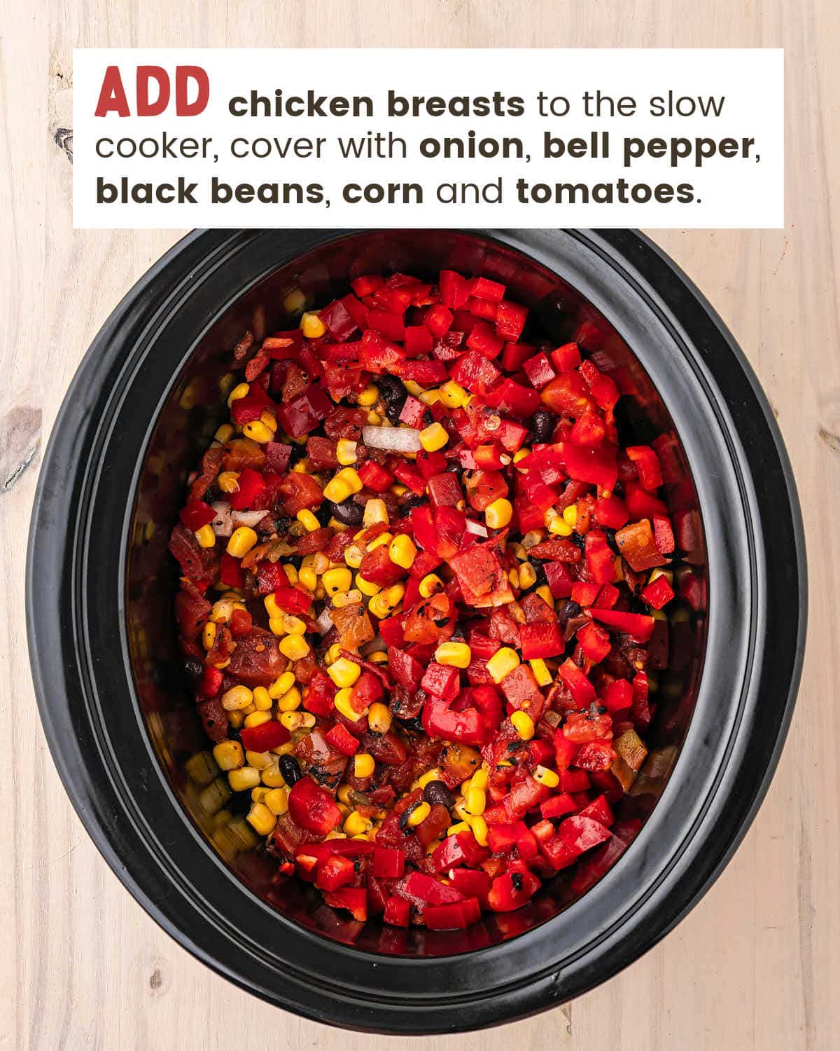 Red bell pepper, corn, black beans, onion and tomatoes with green chiles piled in a black slow cooker.