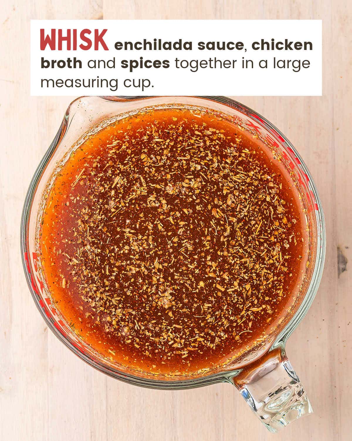 Enchilada sauce, chicken broth and dried spices whisked together in a glass measuring cup.