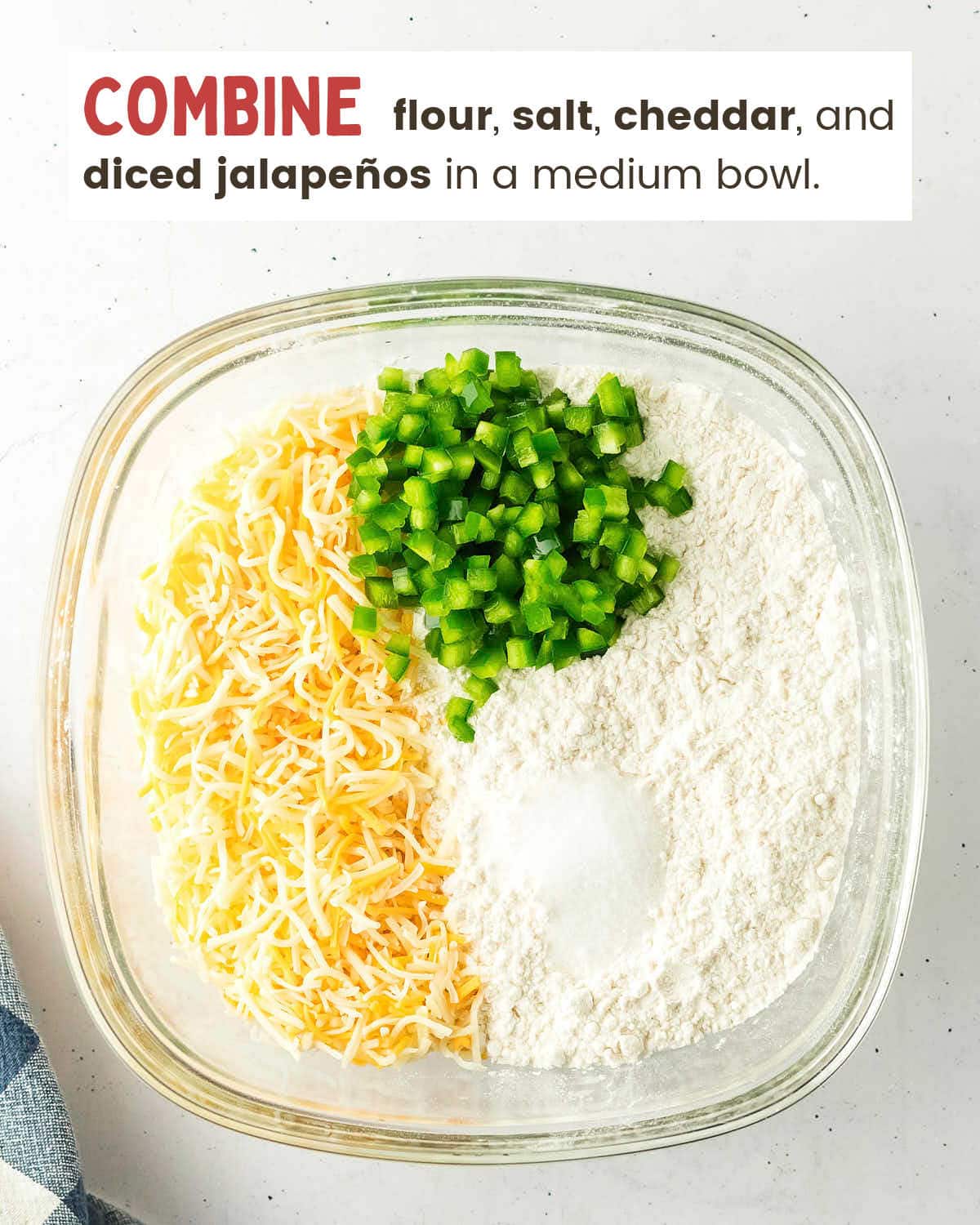 Flour, salt, shredded cheese, and diced jalapeños combined in a bowl for Jalapeño Cheddar Bread.