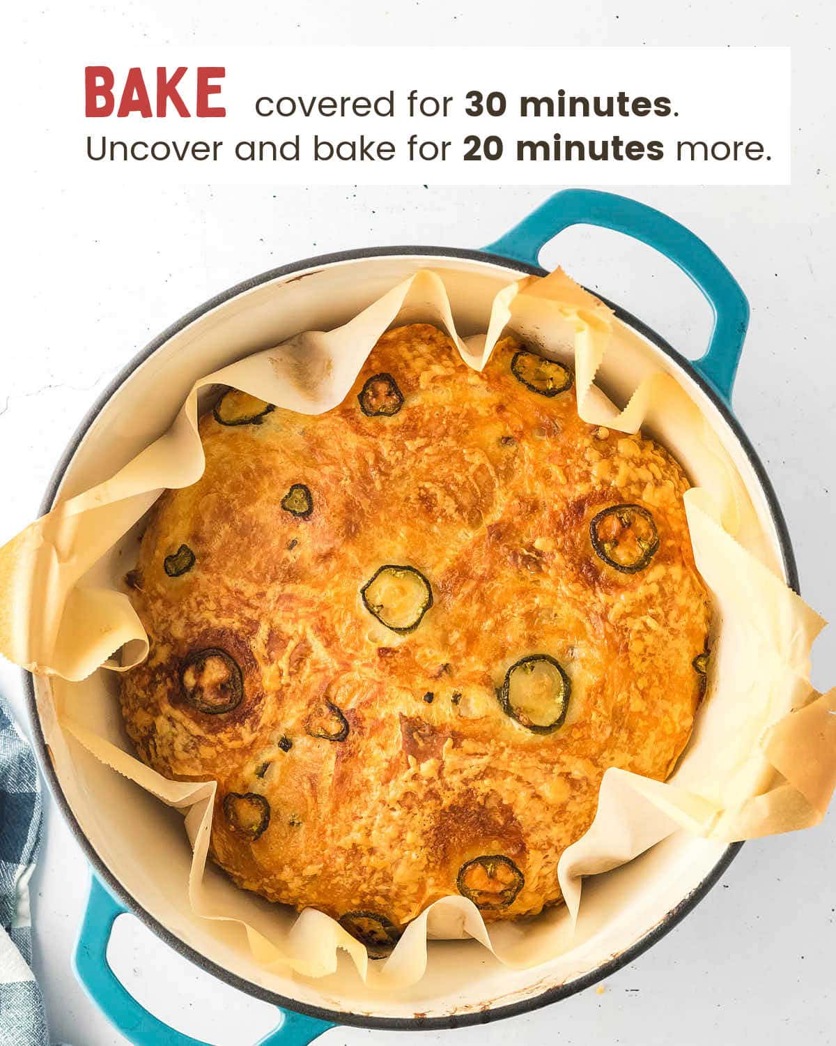 Shaped dough topped with shredded cheese and fresh jalapeño slices before baking.
