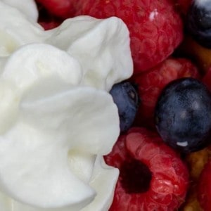 Slice of gluten-free Belgian Waffles with fresh berries and whipped cream