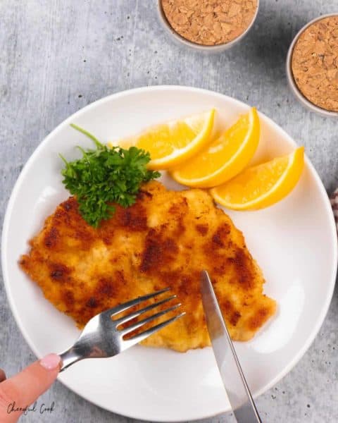 Cutting into the chicken schnitzel.