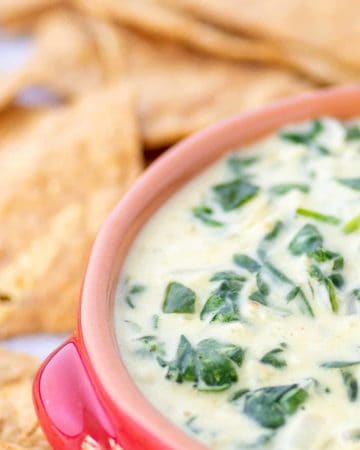 A bowl of warm Spinach Dip with Nachos chips for dipping