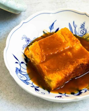 A plate of warm custard bread pudding with homemade caramel sauce