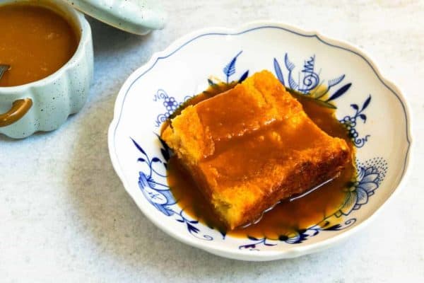 A plate of warm custard bread pudding with homemade caramel sauce