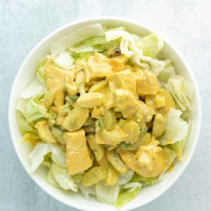 A bowl of curry chicken salad with grapes