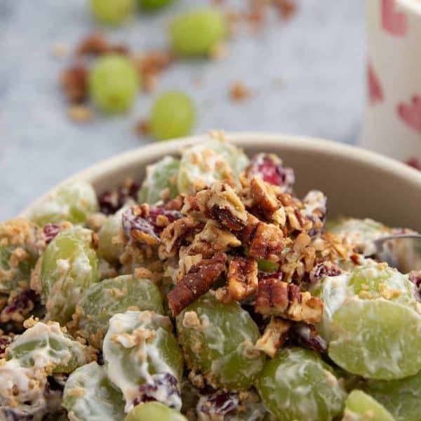 A bowl full of Grape Salad with cranberries and Graham Crackers