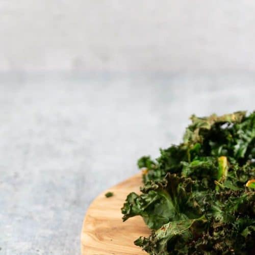 roasted kale on wooden plate ready for snacking