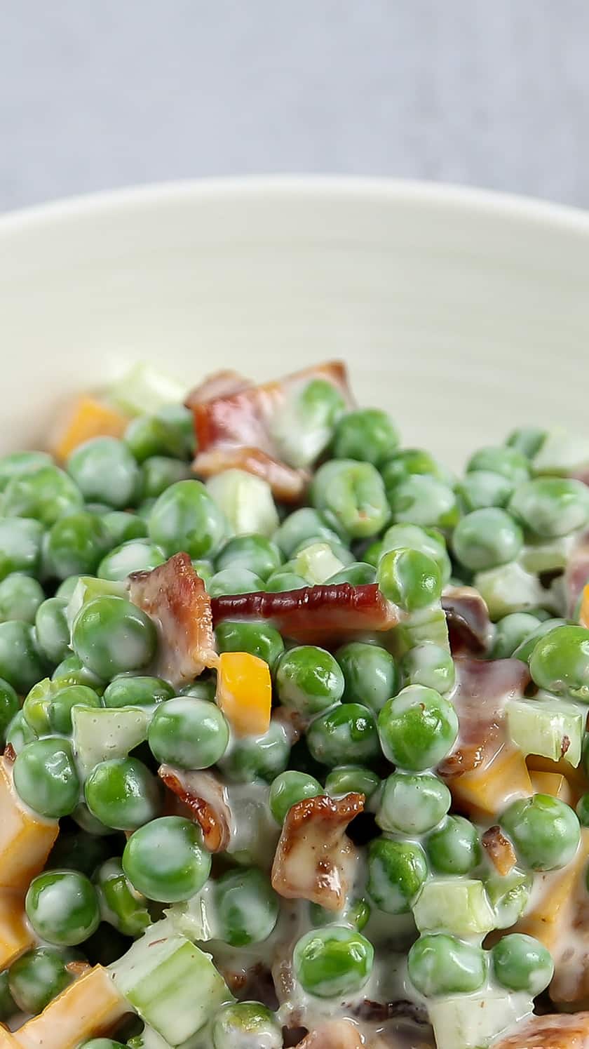 A bowl of pea salad with bacon.