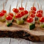 Tomato, feta, and cucumbers each neatly threaded onto a wooden skewer.