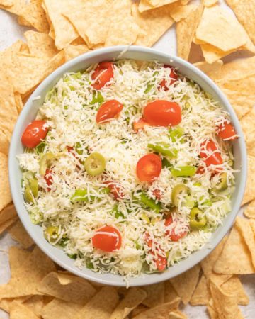 A bowl of taco dip with chips